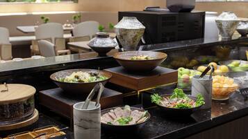 A buffet setup with various dishes and a coffee station.