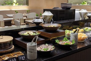 A buffet setup with various dishes and a coffee station.