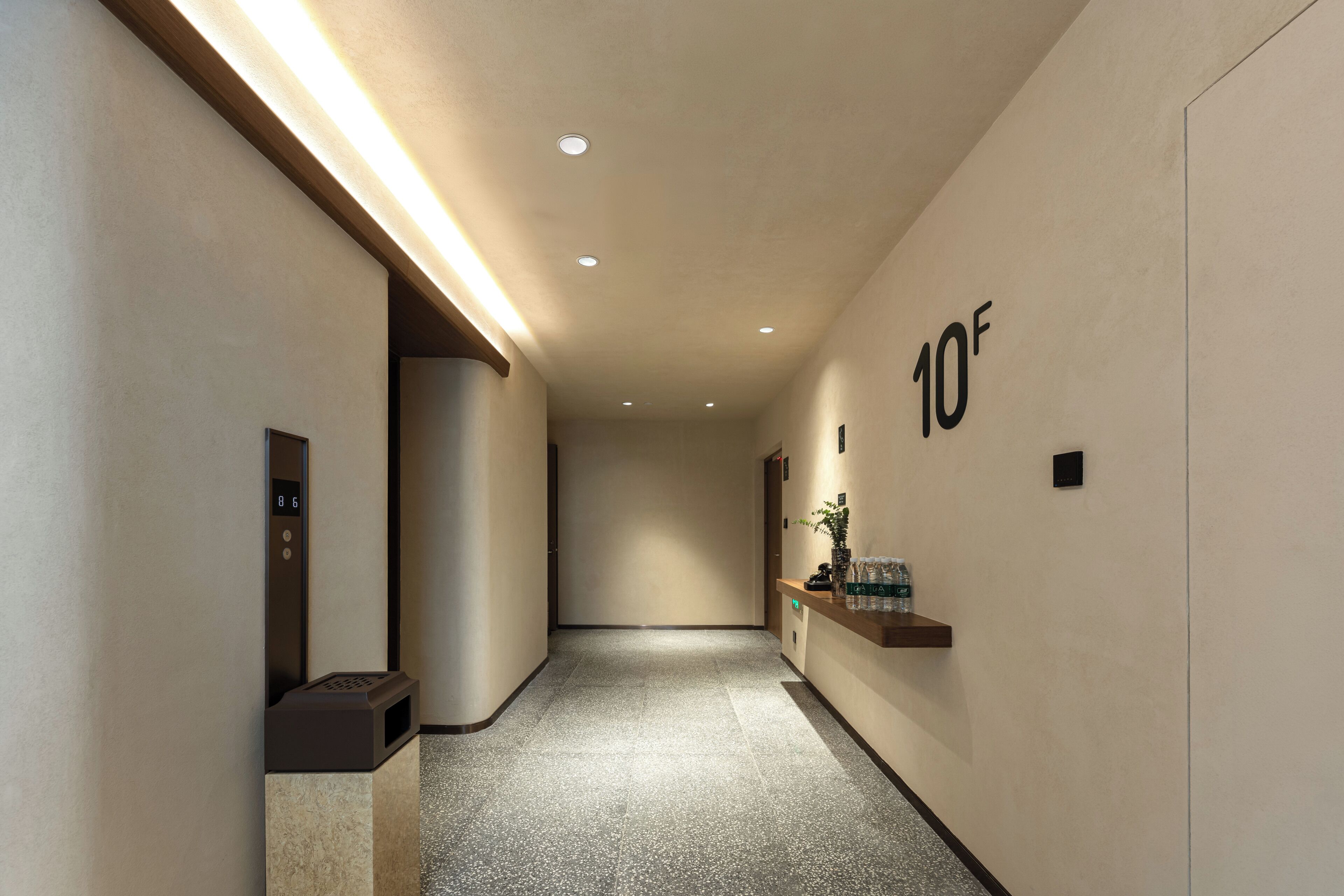 A hallway with a reception desk, a water dispenser, and a sign indicating the floor level.