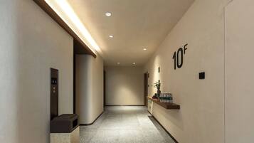 A hallway with a reception desk, a water dispenser, and a sign indicating the floor level.