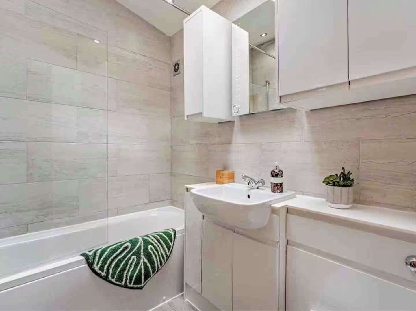 Ein modernes Badezimmer mit Badewanne, Waschbecken und Spiegel.