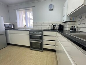 Eine moderne Küche mit Backofen, Mikrowelle und Kaffeemaschine.