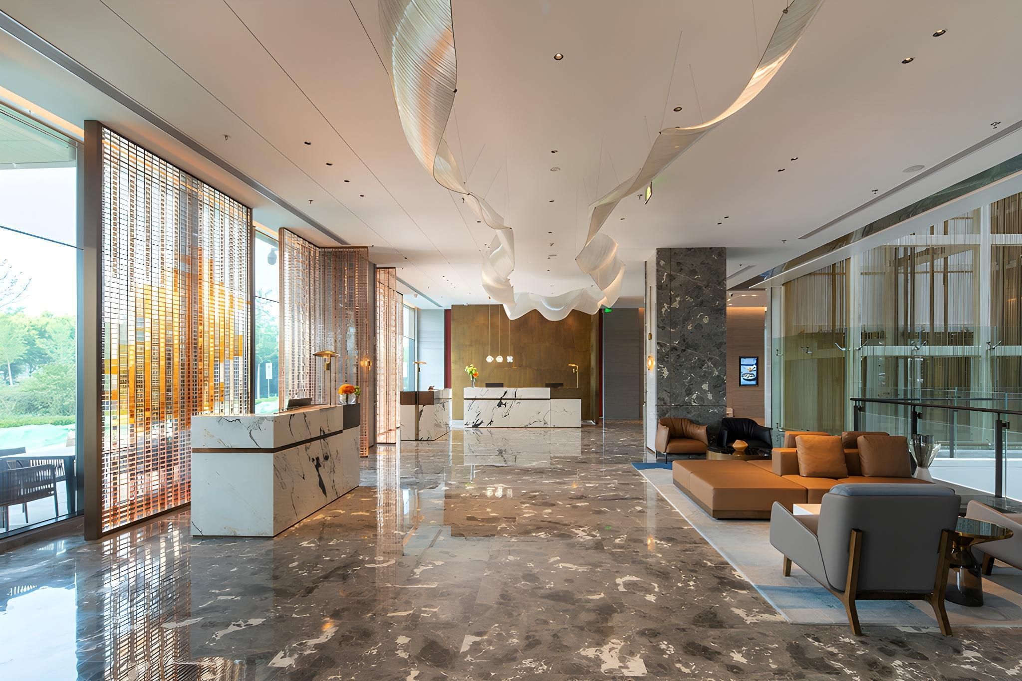 A spacious lobby with a reception desk, seating area, and large windows offering views.