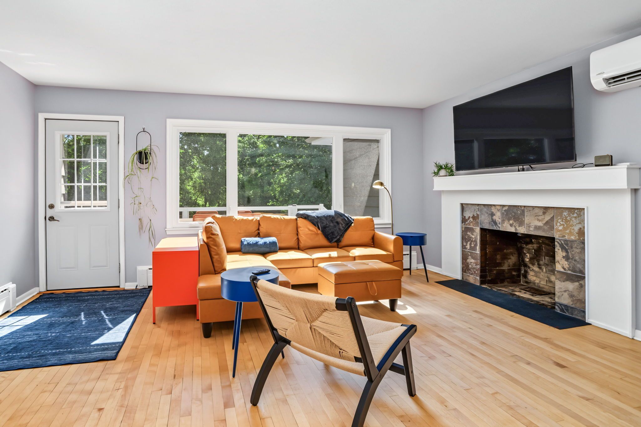 A modern living room with a sofa, a coffee table, a fireplace, and a television.