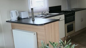 A compact kitchen with a built-in stove, oven, and sink.