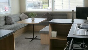 A compact living space with a kitchenette, seating area, and a television.