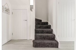 Eine Treppe mit Teppichstufen, die zu einer weißen Tür führt.