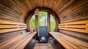 Un sauna avec des bancs en bois et un appareil de chauffage de sauna de la marque Harvia.