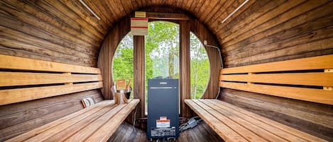 Una sauna con bancos de madera y un calentador de sauna Harvia.