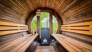 A sauna with wooden benches and a Harvia sauna heater.