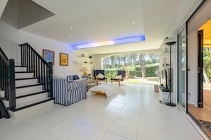 Ein modernes Wohnzimmer mit Treppe, Sofa, Couchtisch und Fernseher.