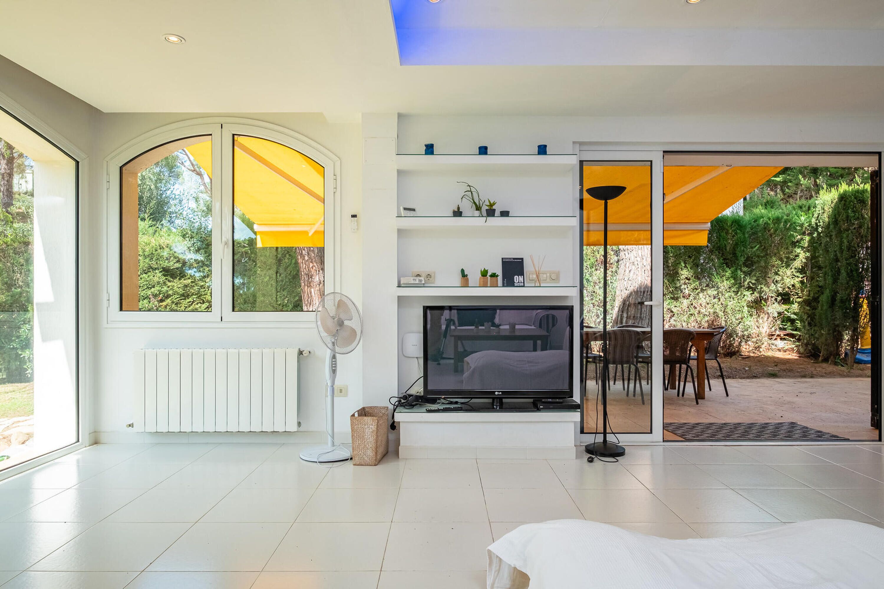 A modern living room with a fireplace, a TV, and a dining area with outdoor seating.