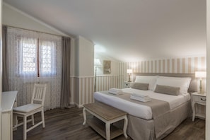 A bedroom with a bed, bedside tables, a chair, a bench, and a window with curtains. - B&b L'ulivo Fiumicino (Fiumicino)