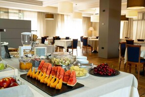 A buffet setup with various fruits and a fruit carving display. - La Pieve Hotel (Chiampo)
