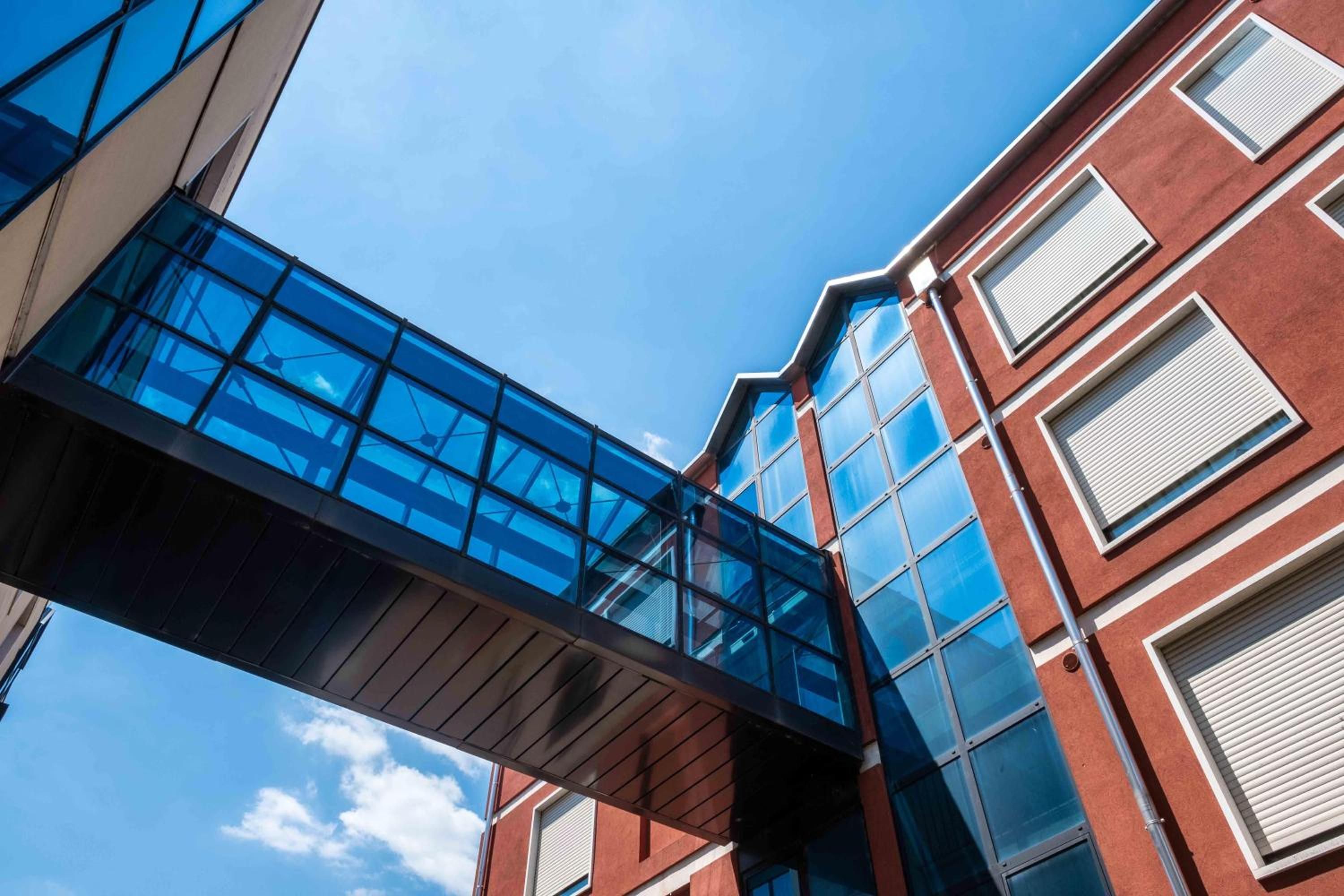 A modern building with a glass bridge connecting two sections.
