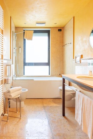 A modern bathroom with a bathtub, toilet, and sink. - La Pieve Hotel (Chiampo)