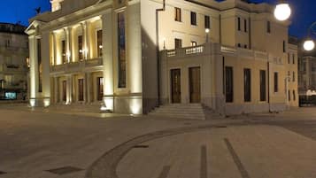 Un grande edificio in stile classico con un ingresso imponente e una scalinata che vi conduce.