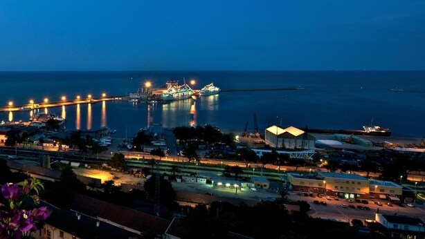 A coastal cityscape at dusk with illuminated buildings, a marina, and a bridge. - Hotel Ideale (Ortona)