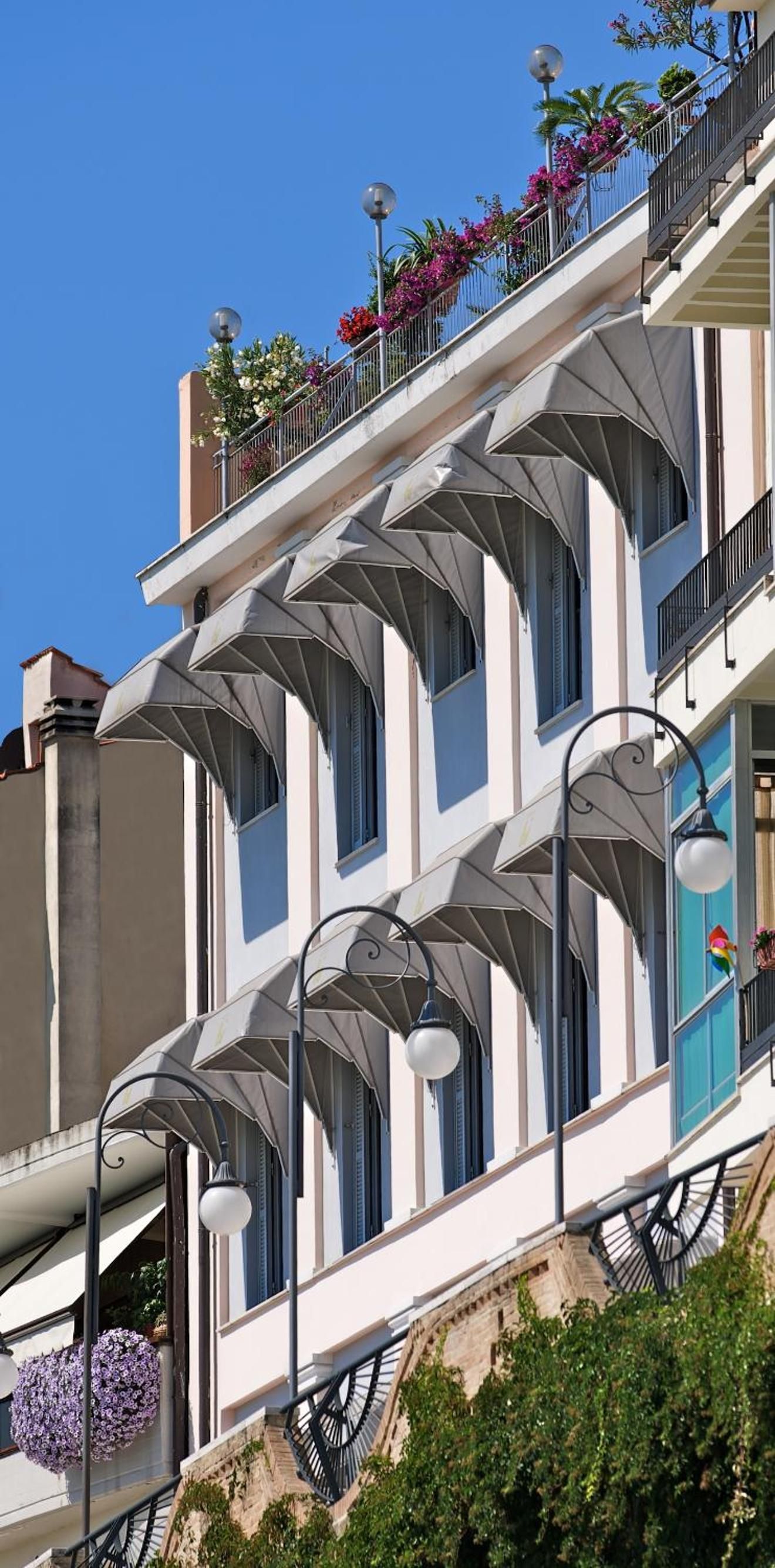 Un edificio a più piani con balconi, ampie finestre e illuminazione esterna.