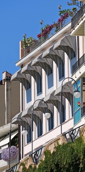 A multi-story building with balconies, large windows, and outdoor lighting fixtures. - Hotel Ideale (Ortona)