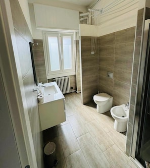Un bagno moderno con doccia, toilette, bidet e lavandino.