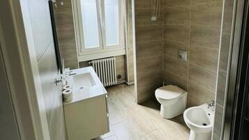 Un bagno moderno con doccia, toilette, bidet e lavandino.