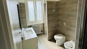 Un baño moderno con ducha, inodoro, bidé y lavamanos.