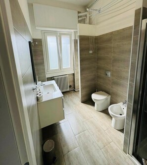 Un baño moderno con ducha, inodoro, bidé y lavamanos.