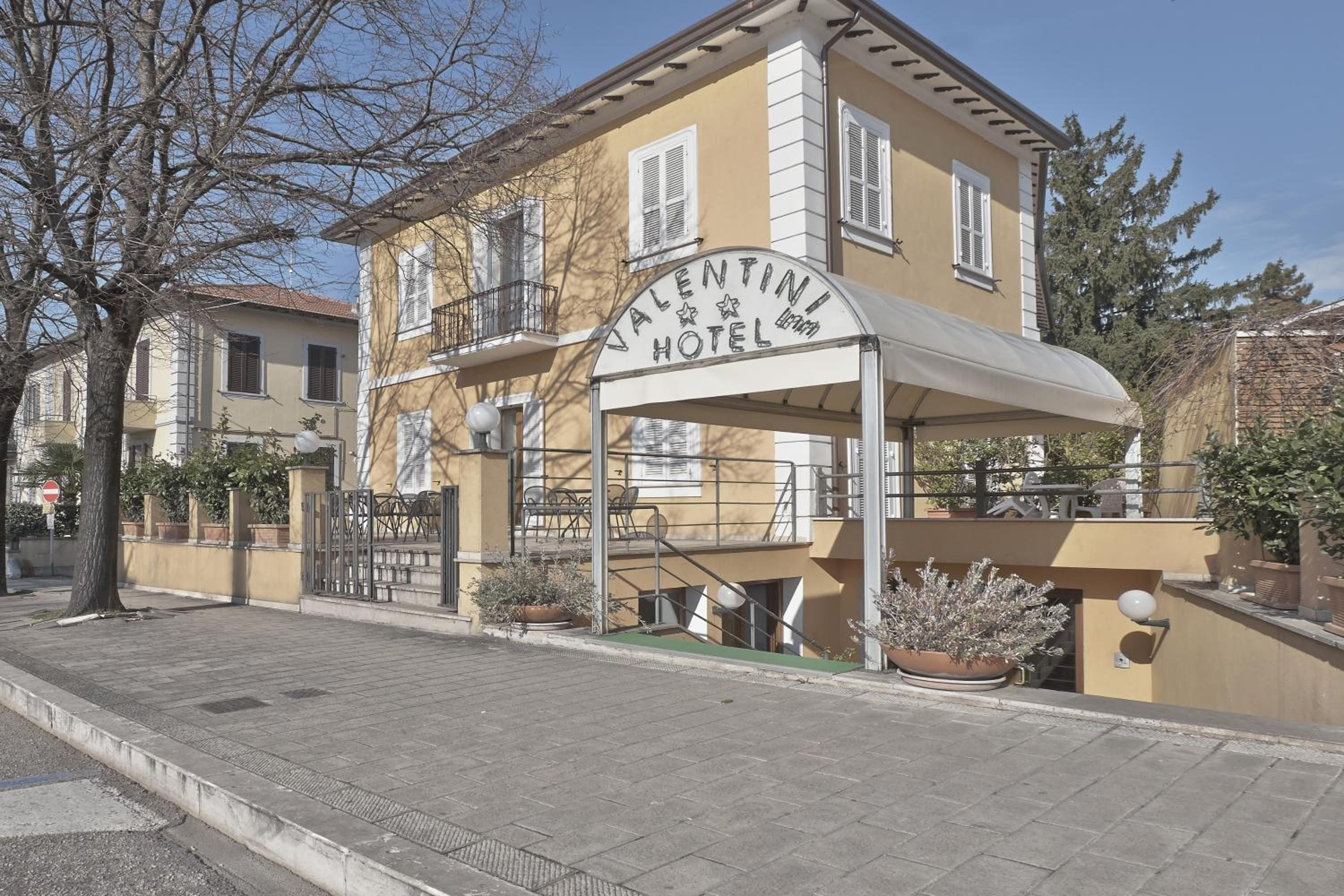 Un edificio di due piani con un cartello che riporta 'Valentini Hotel'.