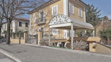 Un edificio di due piani con un cartello che riporta 'Valentini Hotel'.