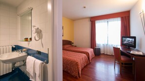 A hotel room with a bathroom, a bed, a desk, and a television. - Hotel La Cascata (Azzano San Paolo)