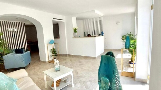 A modern living room with a sofa, coffee table, and decorative items. - Hotel Guarracino (Capri)