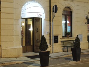 A hotel entrance with a white awning, a bench, and two potted plants. - Albergo Ma.re (Popoli)