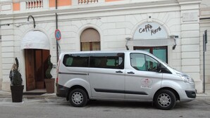 Una furgoneta plateada estacionada frente a un edificio con un letrero que dice 'Caffe Mare'.
