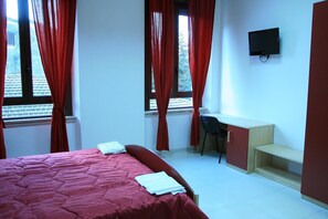 A bedroom with a bed, a desk, a chair, and a television. - Albergo Ma.re (Popoli)