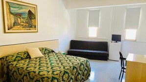 A room with a bed, a desk, a chair, and a television. - Franco Il Conte (Bagheria)