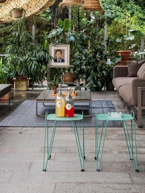 Un espace extérieur aménagé avec une table, des chaises et un tableau encadré.