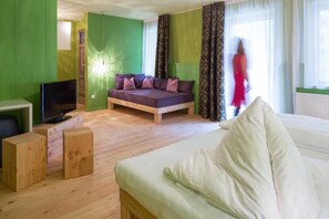 A modern living room with a sofa, a television, and a bed. - Frida Am Wald (Rasun Anterselva)