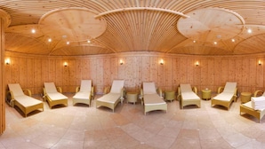 A sauna room with multiple sun loungers and a wooden ceiling. - Frida Am Wald (Rasun Anterselva)