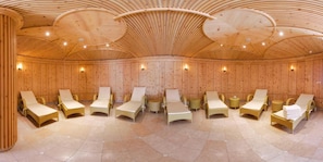Un sauna doté de plusieurs chaises longues et d’un plafond en bois.