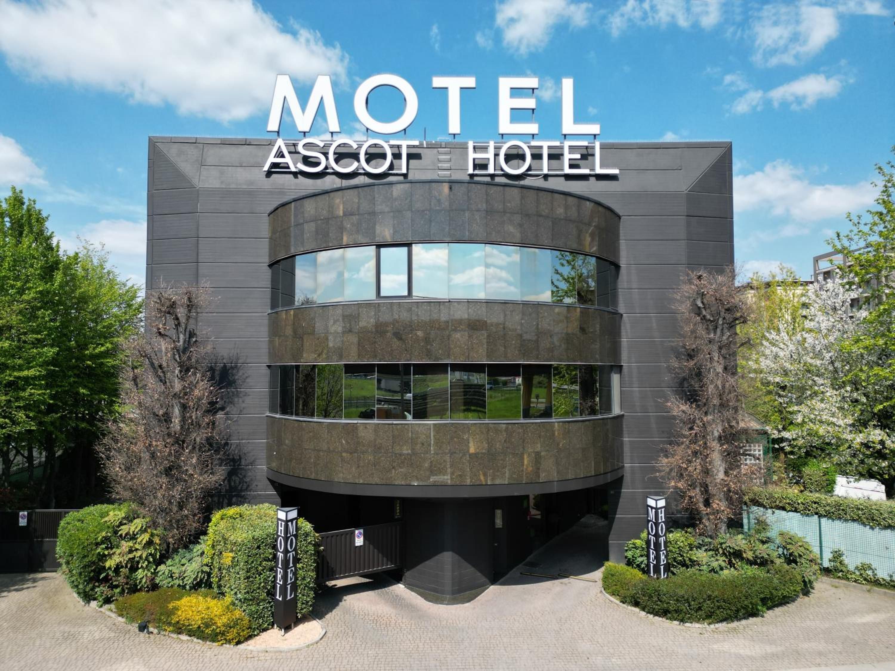 A modern building with a curved facade and large windows, labeled as 'Motel Ascot Hotel.'