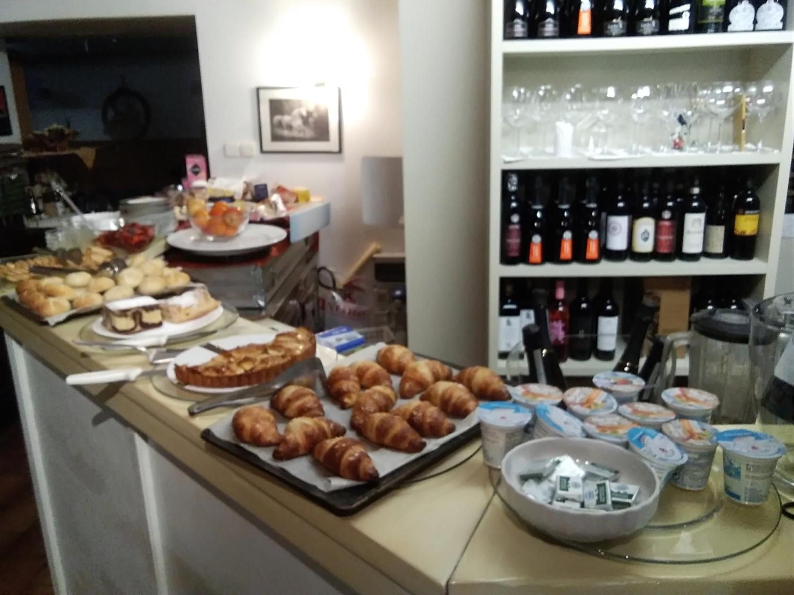 Un tavolo con buffet assortito e una selezione di bottiglie di vino.