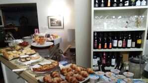 A buffet table with various food items and a selection of wine bottles. - B&b Hotel Dolomiti (Bolzano)