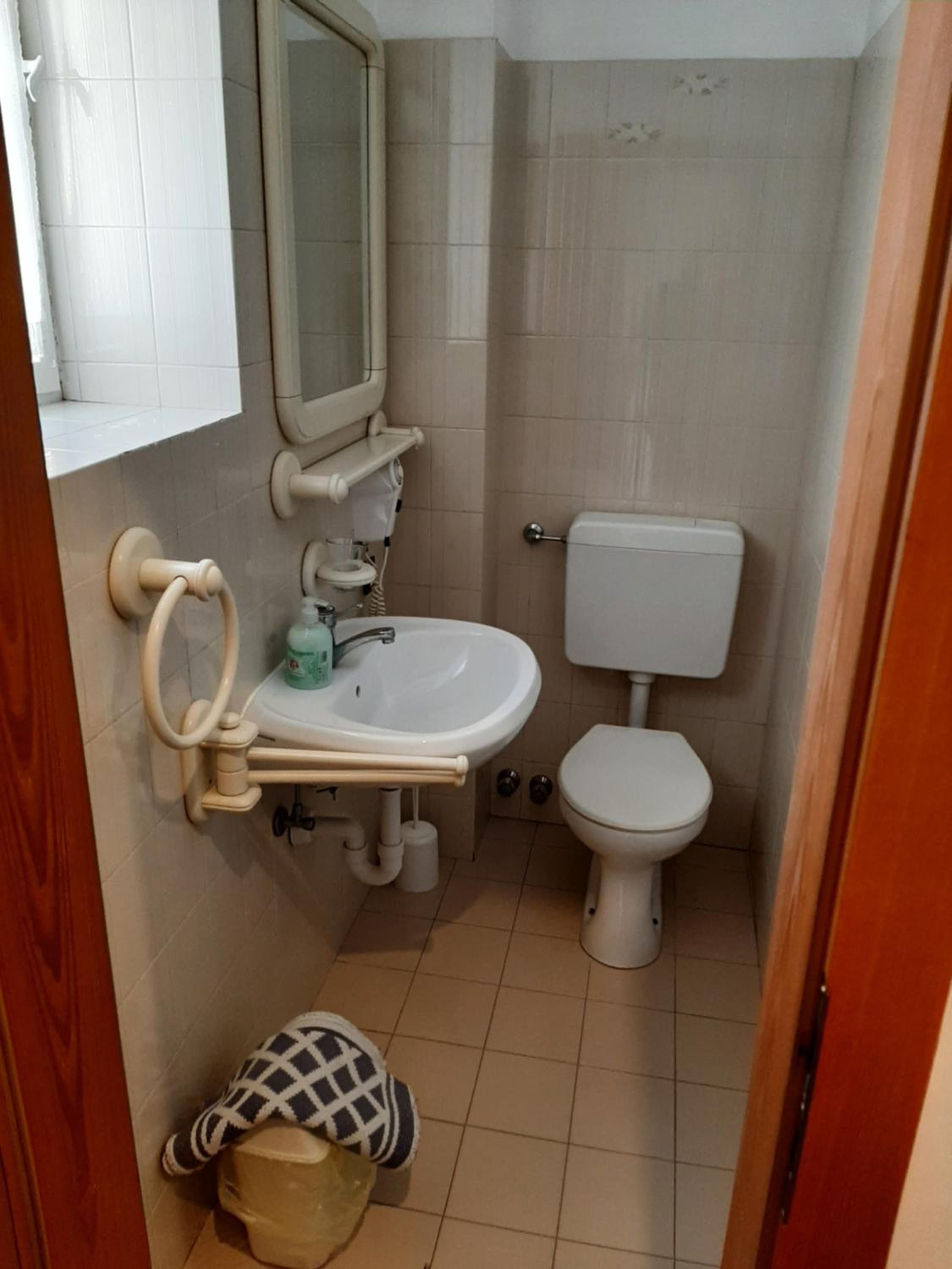 Un bagno piccolo con il water, un lavandino e uno specchio.