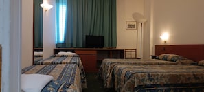 A hotel room with two beds, a desk with a television, and a standing lamp. - Park Hotel Galileo (Reggello)