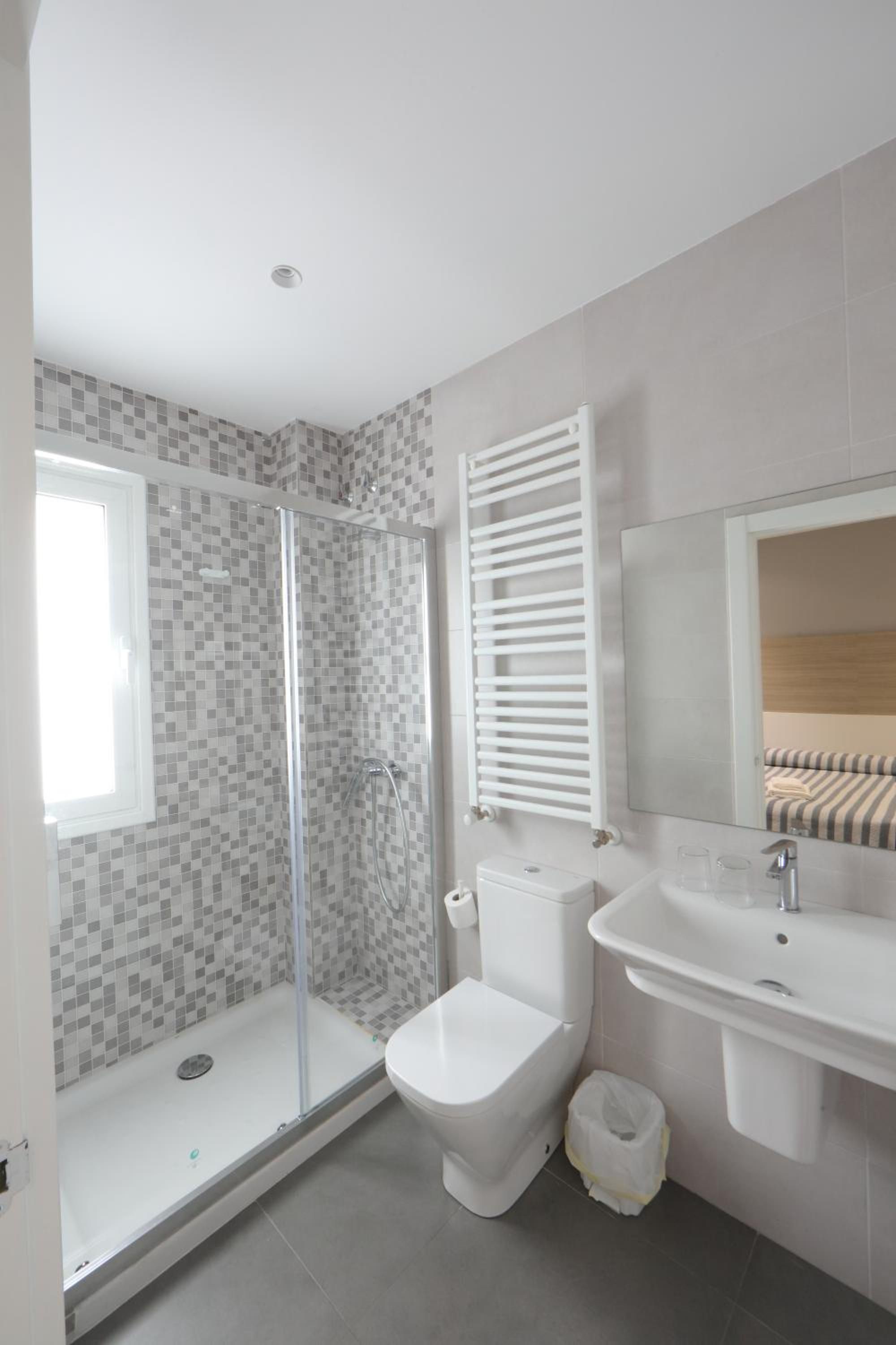 Un baño moderno con ducha, inodoro y lavamanos.