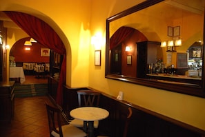 A restaurant interior with a dining area, a bar, and a large mirror reflecting the bar area. - Locanda Le Logge (Urbisaglia)
