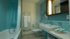 Baño con bañera, ducha, inodoro y lavamanos.