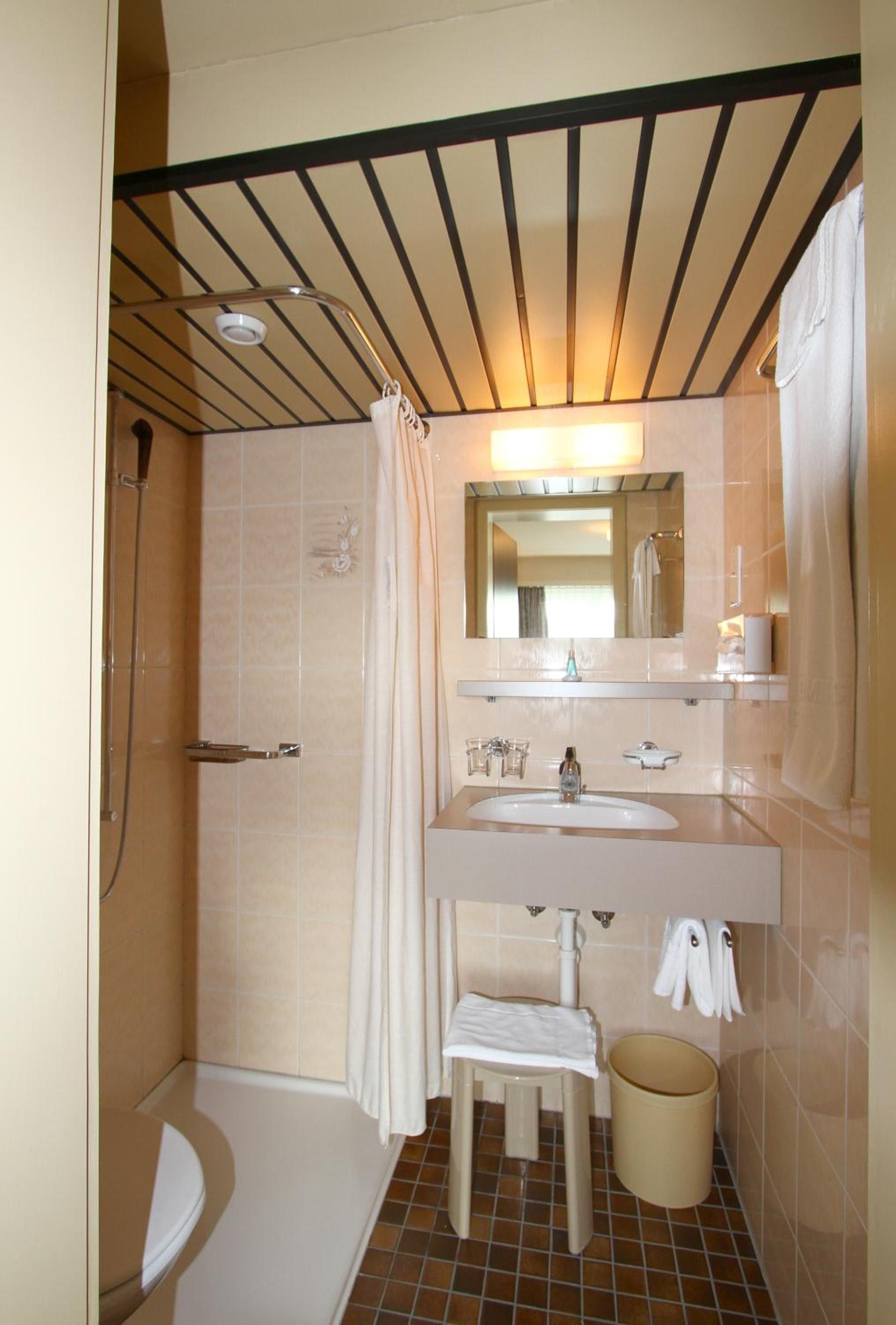 A compact bathroom with a shower, toilet, and sink.