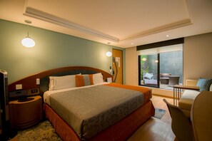 A hotel room with a large bed, a desk, a chair, and a view of the outdoors. - Hotel Catalina (Mexico City)